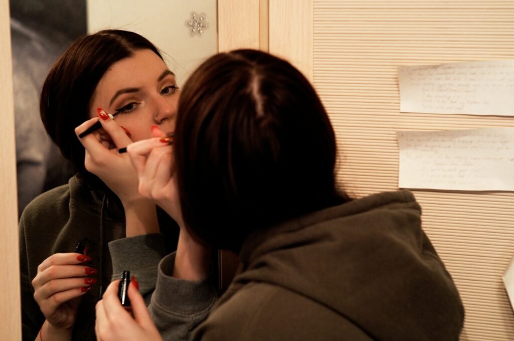 a woman putting makeup on her face